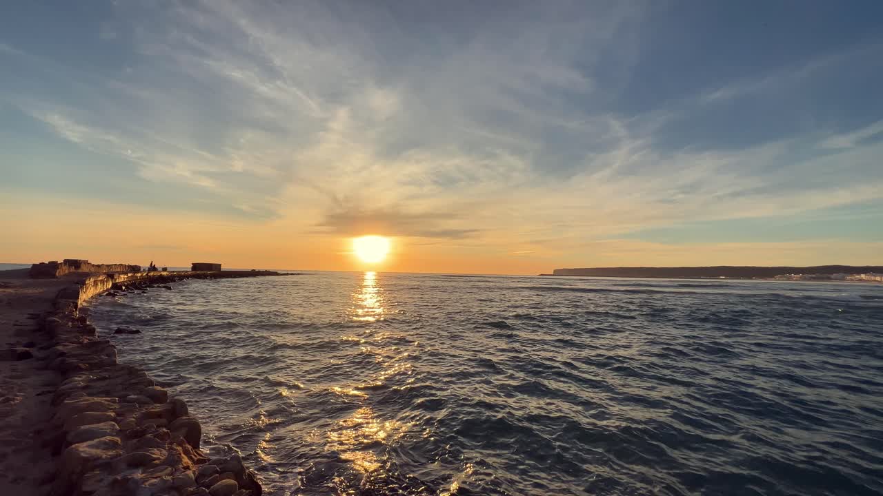 해변의 파도와 아름다운 색의 반사와 함께 물 위에 아름다운 일몰