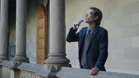 Student-holding-glass-of-champagne-in-hallway