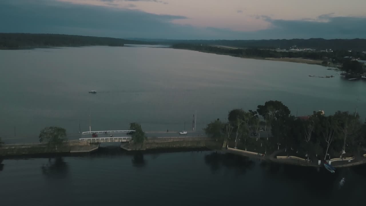 Aerial drone shot revealing a bridge in the middle of the lake in Flores Peten, Guatemala