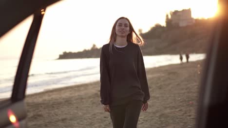 portrait of a woman walks by autumn beach to the car