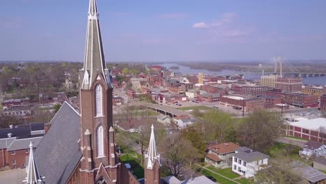 aerial shot over small town america church reveals burlington iowa with mississippi river background