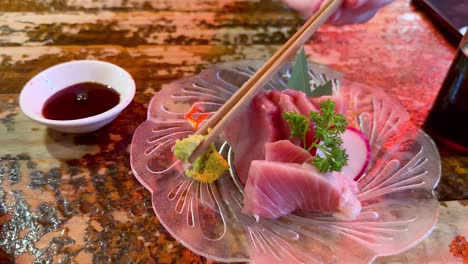 chopsticks with sashimi and soy sauce