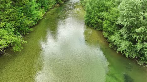 slow motion drone above turquoise river stream between lush forest logar valley slovenia