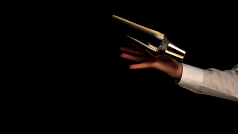 barman shaking a cocktail on black background