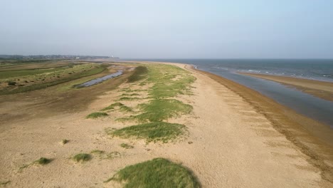 toma aérea de la costa de norfolk con dunas de arena y olas a la vista en dirección a hunstanton con marismas