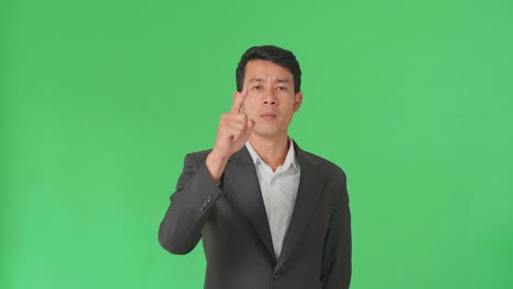 Asian Business Man Threatening With Finger In The Green Screen Studio