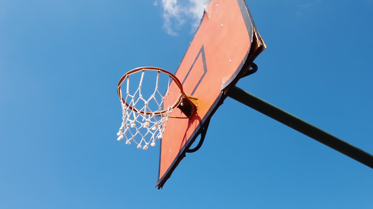 malla de la red de la canasta de baloncesto desde abajo contra el fondo del cielo azul