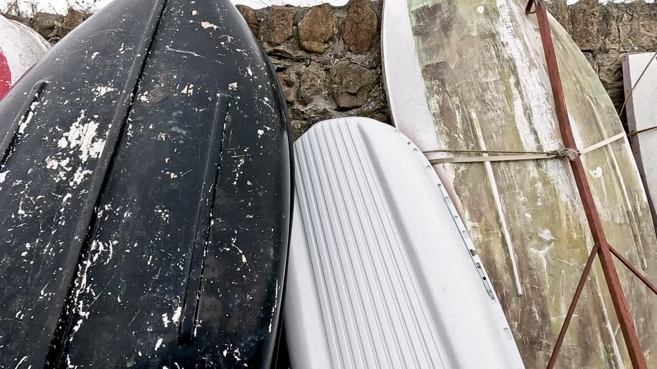 Various boats stored along a stone wall