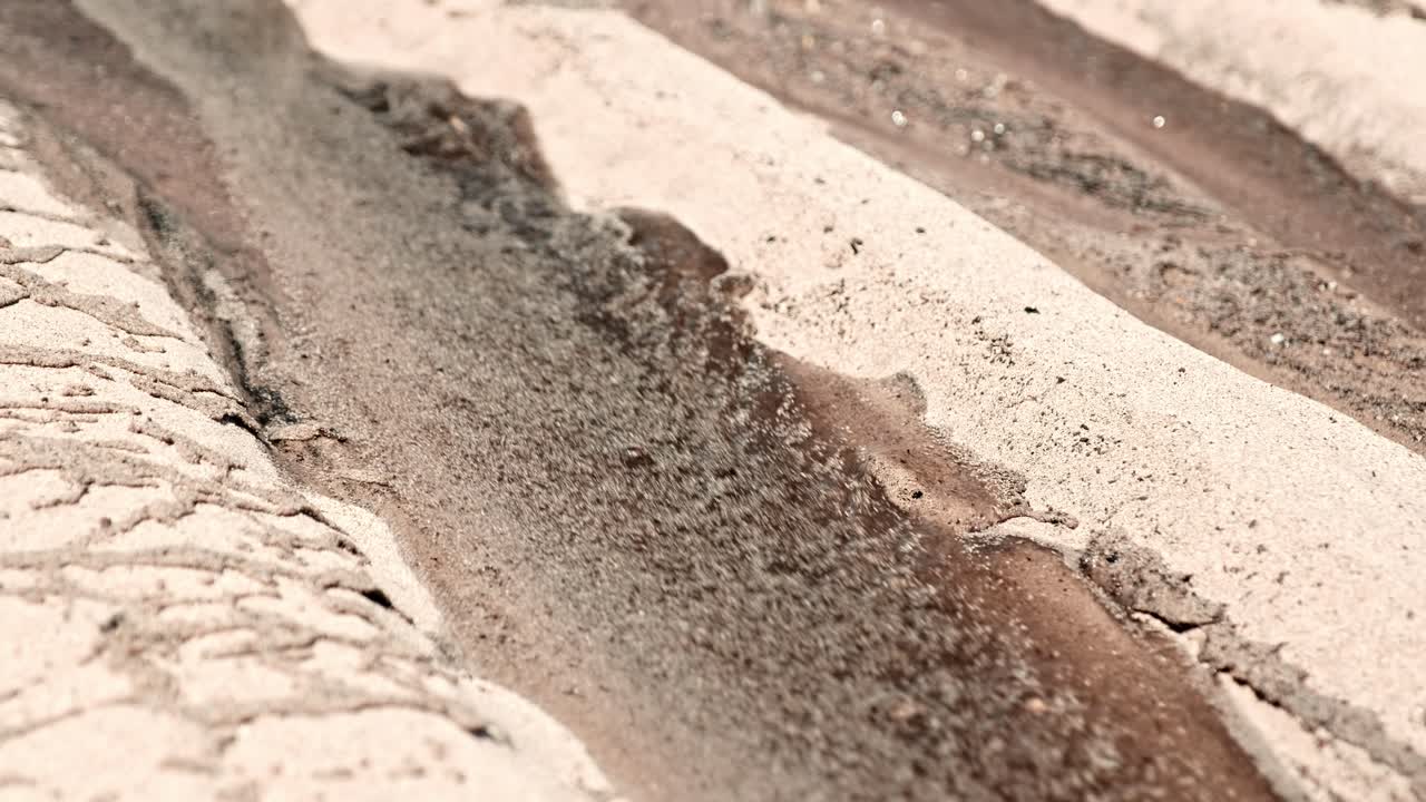 물은 건조한 모래 위로 흐른다.