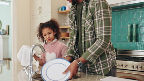 father and daughter doing dishes in the kitchen
