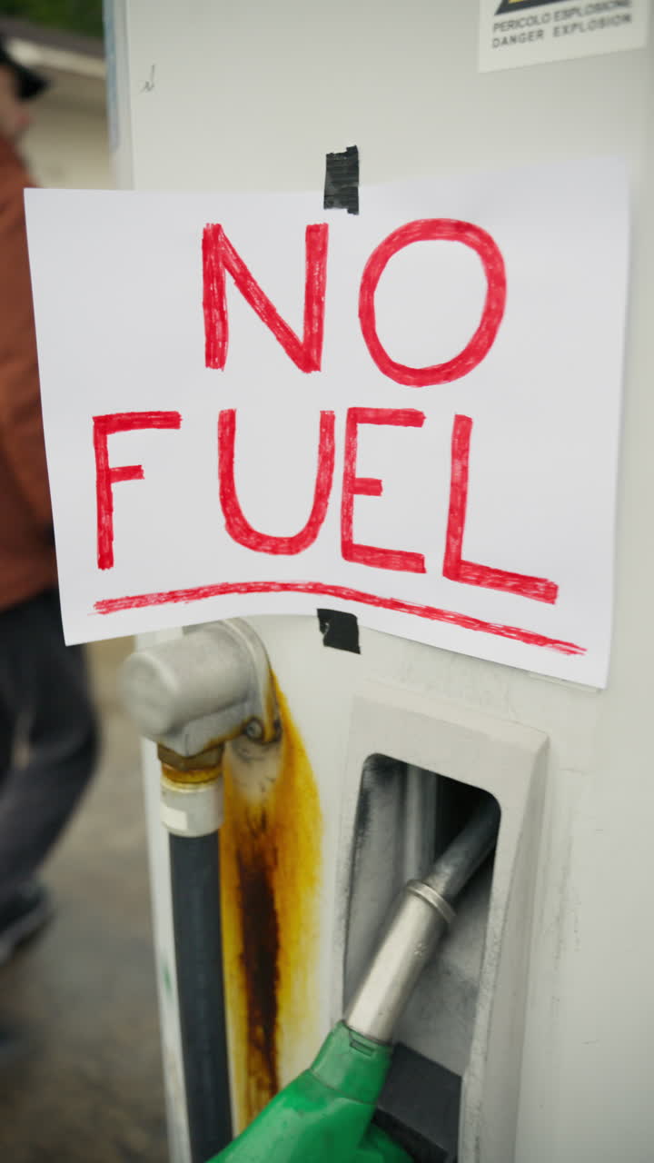 Cartello rosso scritto a mano "No carburante" all'esterno del distributore di benzina in crisi