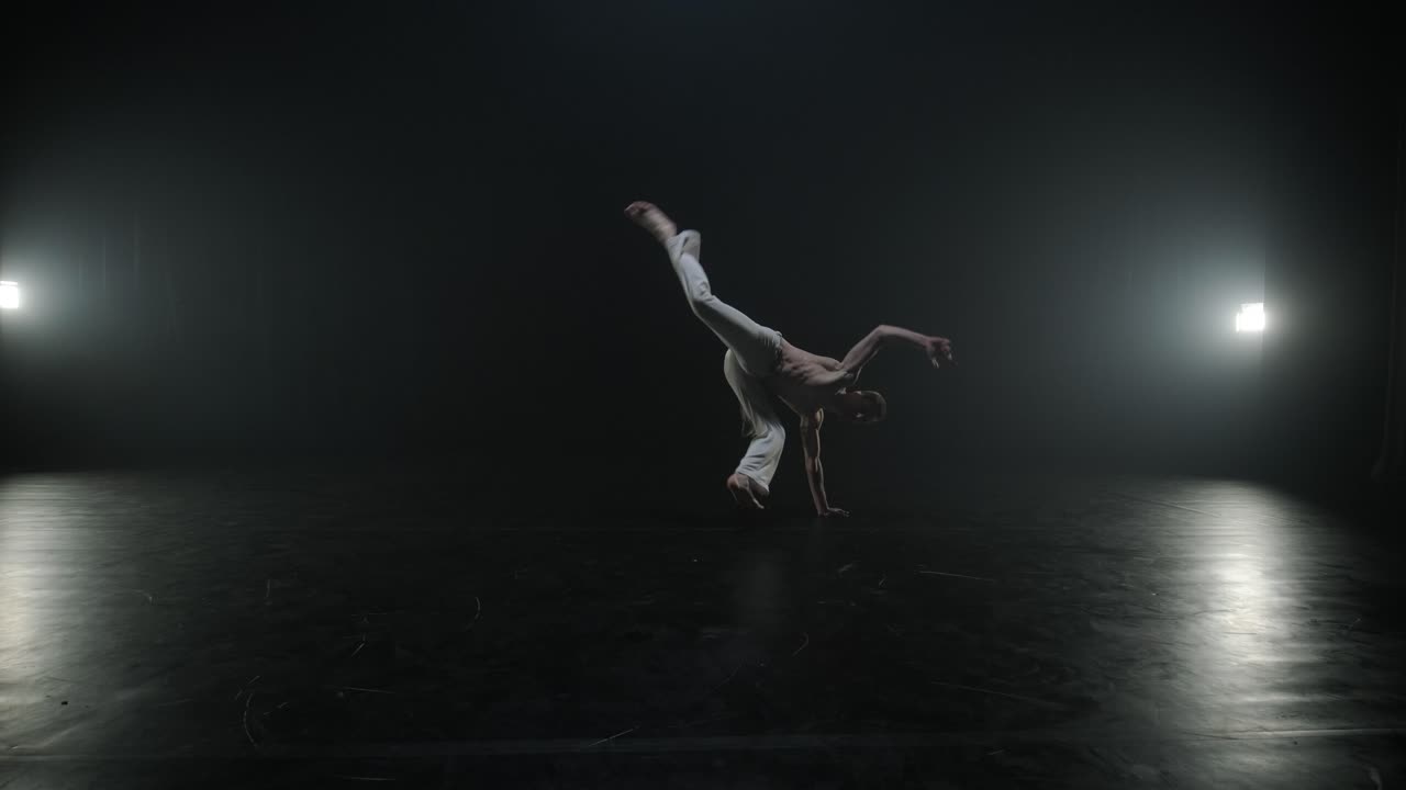 luchadores de capoeira realizando movimientos dinámicos en el escenario. artes marciales, danza y acrobacias en acción. atletas de pecho desnudo mostrando fuerza, flexibilidad y técnica bajo los reflectores