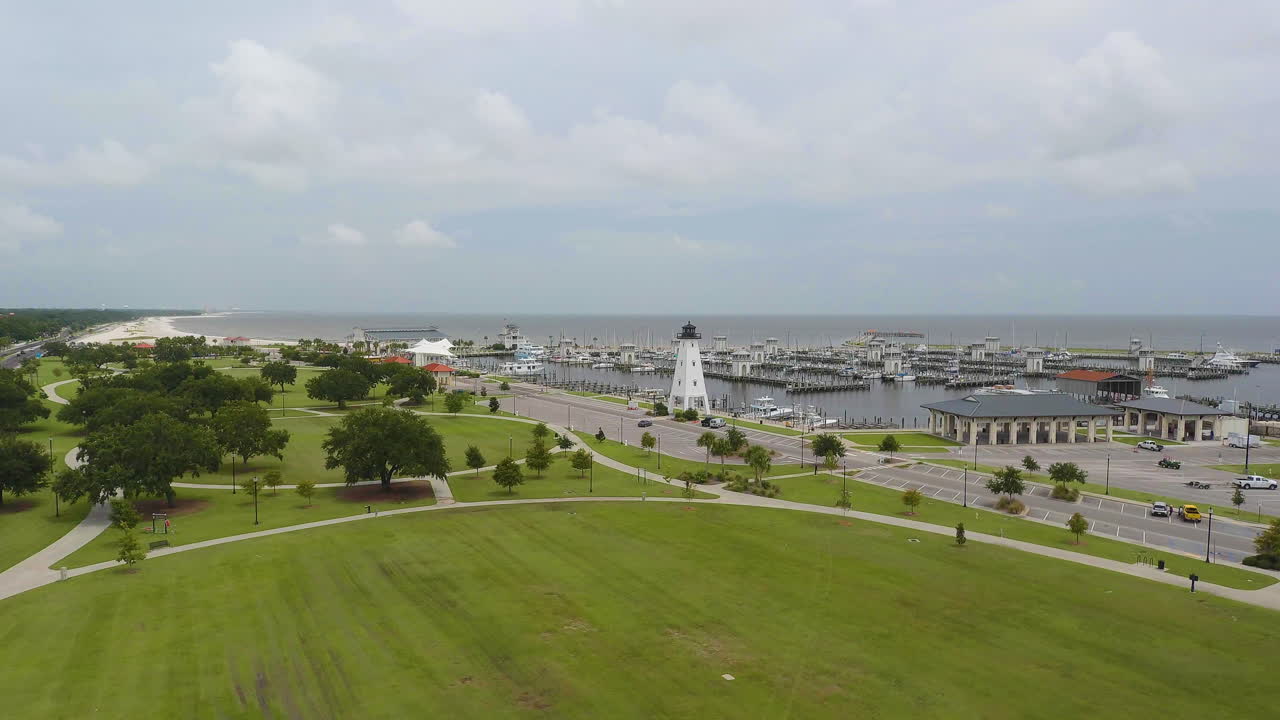 바다 가장자리에 있는 공원에 있는 보트 선착장 가장자리에 있는 등대의 공중 전망