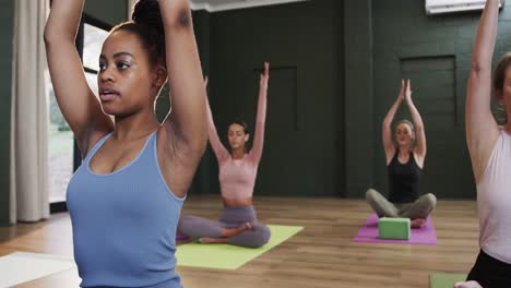 Fokussierte,-Vielfältige-Frauen-Meditieren-Gemeinsam-Auf-Matten-Im-Yoga-Kurs-Mit-Einer-Trainerin,-Zeitlupe