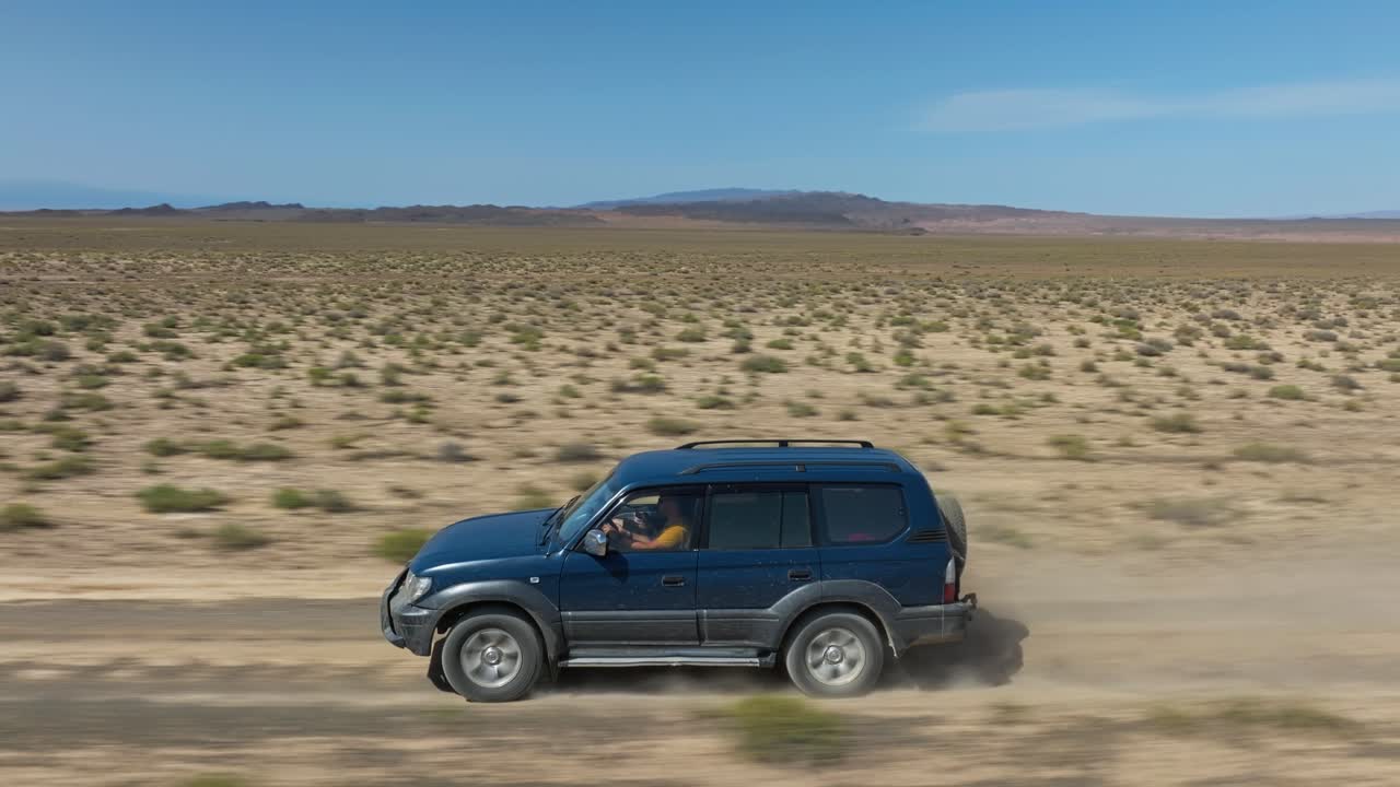 카자흐스탄 의 차린 캐니언 국립 공원 으로 가는 비포장 도로 를 달리는 자동차 의 공중 사진