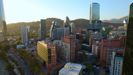 Aerial-establishing-shot-of-Santiago-downtown-skyline-at-sunset,-El-Gold-neighborhood,-Chile