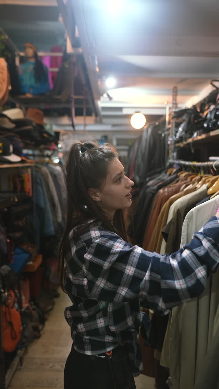 Donna che fa acquisti di abbigliamento vintage in un negozio dell'usato