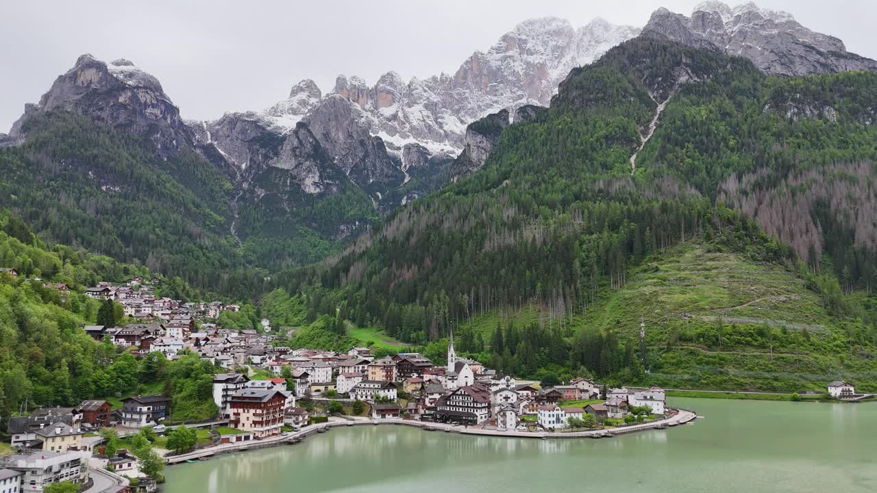 Aerial view of Alleghe village, Lago di Alleghe, Monte Civetta in a drone circular cinematic motion