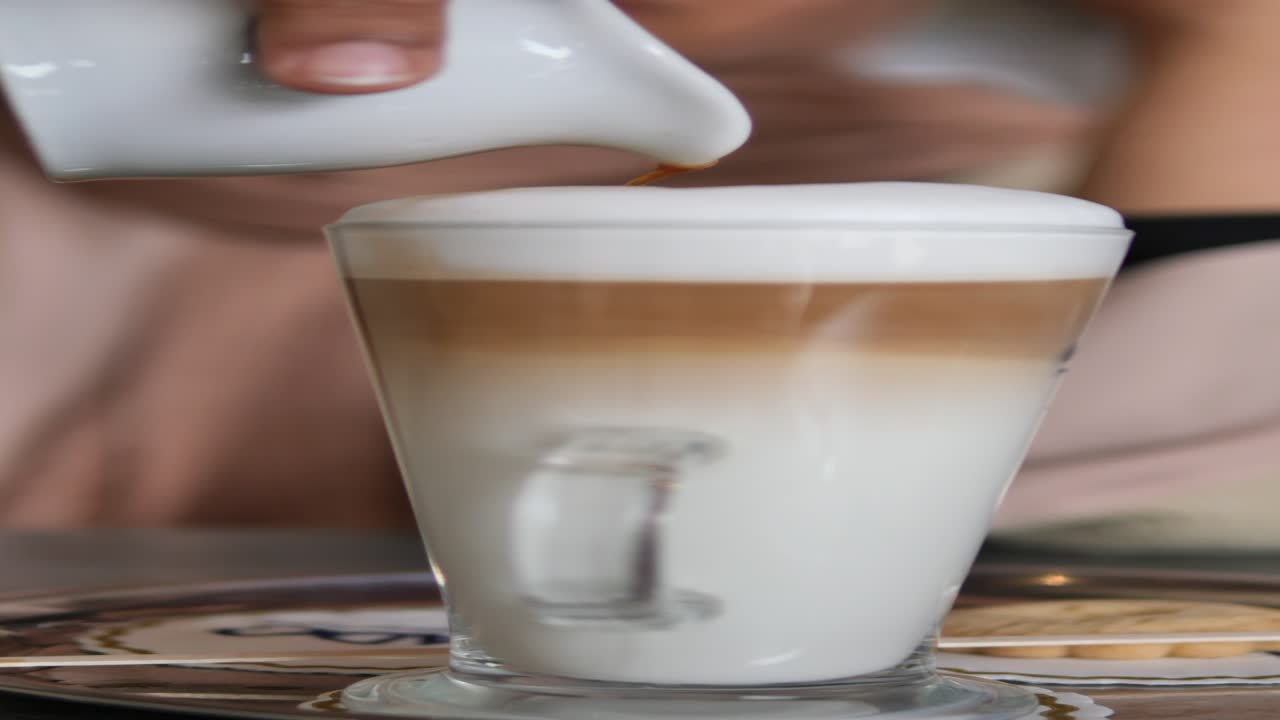 barista vertiendo arte con leche en un vaso