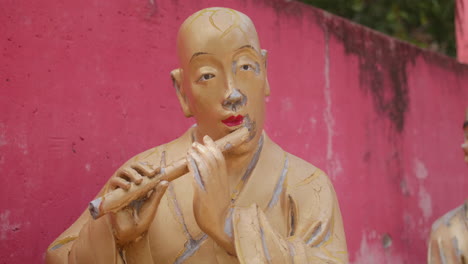 beautiful golden buddha statue playing the flute