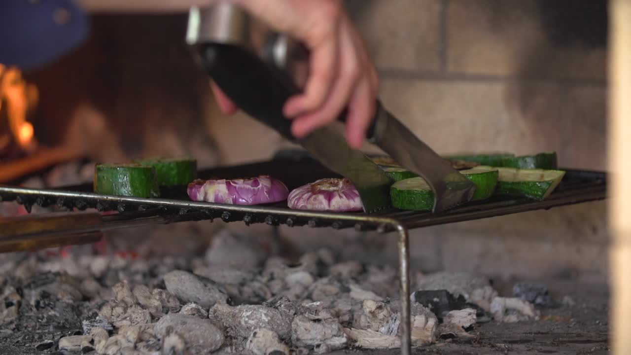 cocinar volteando verduras en la barbacoa con un tenedor de cocina.