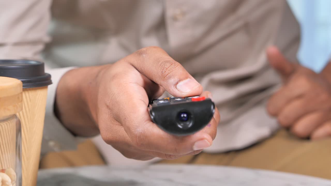 리모컨으로 tv를 보는 남자