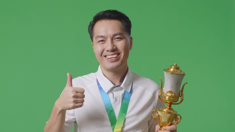 man with trophy and medal