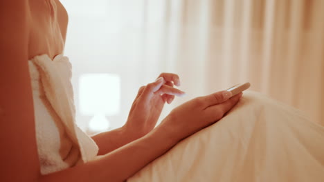 woman using phone in bed at night