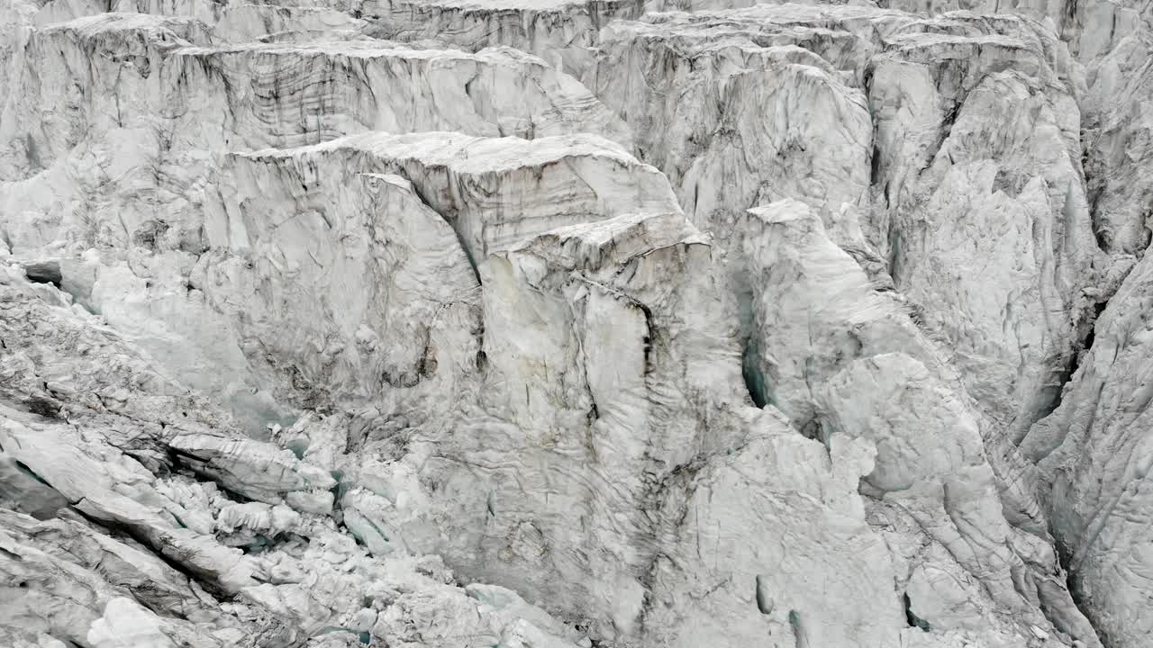 흐린 여름날 스위스 발레에 있는 그리멘츠 근처 모이리 빙하의 크레바스 위로 회전하는 공중 비행