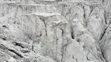 Spinning-aerial-flyover-above-the-crevasses-of-the-Moiry-glacier-near-Grimentz-in-Valais,-Switzerland-on-a-cloudy-summer-day