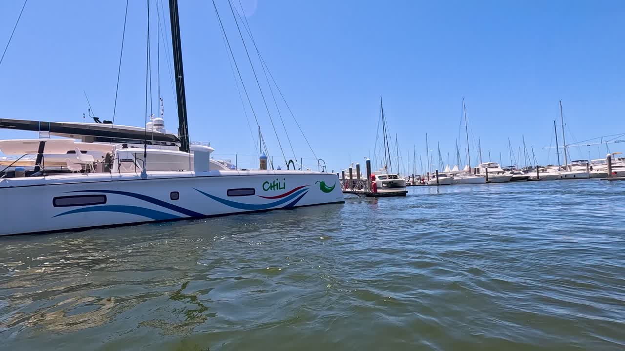 el catamarán se acerca a la marina bajo un cielo azul claro.