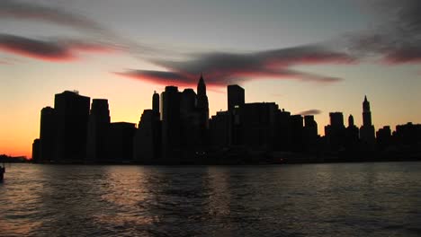 the river reflects the last rays of sunlight in this new york city skyline shot