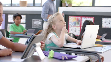 Caucasian girl in a school classroom with a laptop