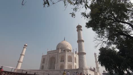 taj mahal magnificence against the clear blue sky seen from side walkway - pan down reveal wide shot