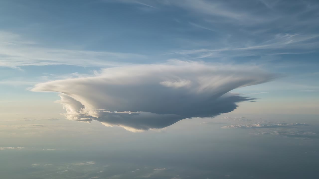 Recording aerial camera capturing isolated anvil cloud shifting over horizon, documenting evolution