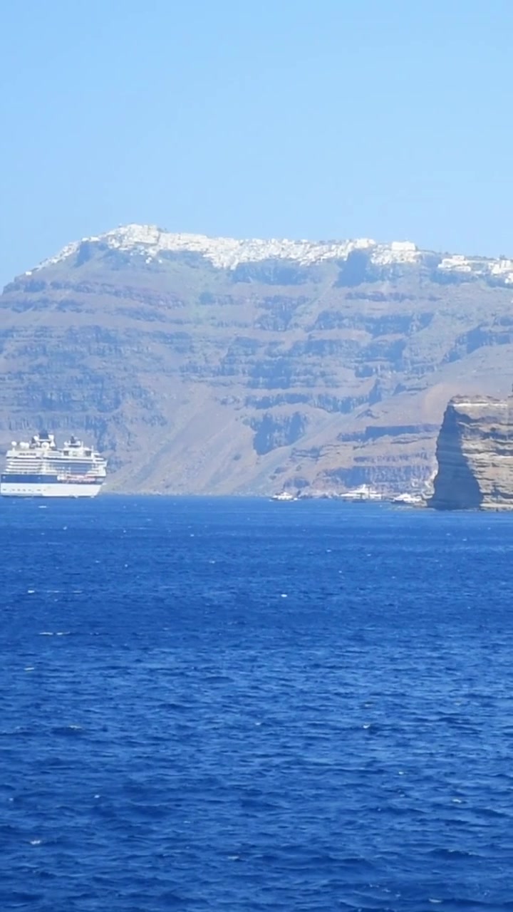 Nave da crociera che naviga nel Mar Egeo avvicinandosi all'isola di Santorini, Grecia
