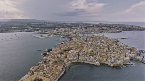 syracuse italy aerial v3 flyover spiaggia di cala rossa beach into ortigia island capturing cityscape of historical district with stone architectural buildings - shot with mavic 3 cine - june 2023