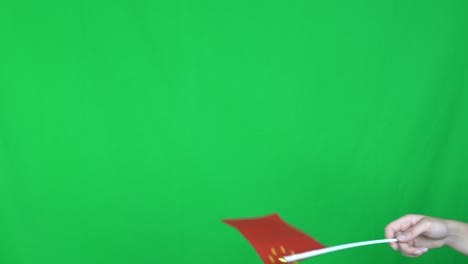 close up de una mano desconocida sosteniendo una bandera de israel en el fondo de la pantalla verde