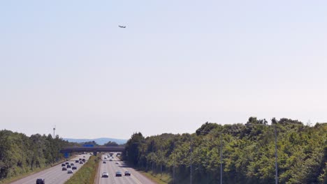 El-Avión-Despega-Hacia-El-Cielo-Sobre-La-Autopista-M1,-Vista-Desde-Feltrim-Road,-Dublín,-Irlanda