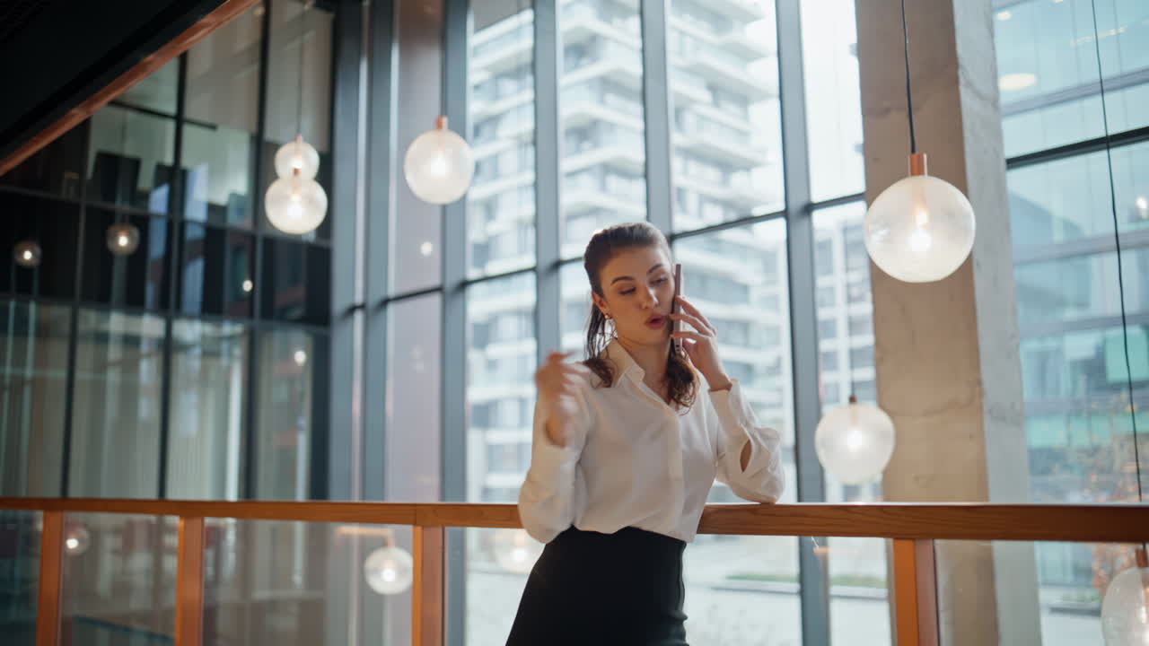 Executive woman calling cellphone in office hall. Elegant businesswoman talking