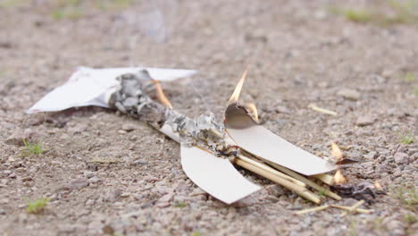 quemando y fumando papel cohete de bricolaje tendido en el suelo, experimento científico fallido