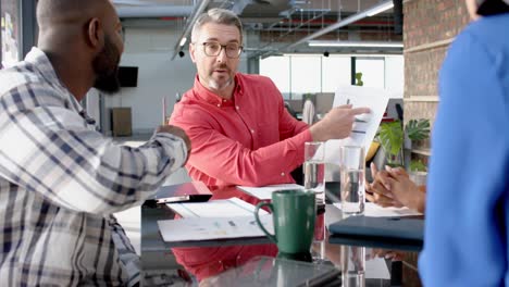 team of diverse colleagues discussing over a document at office