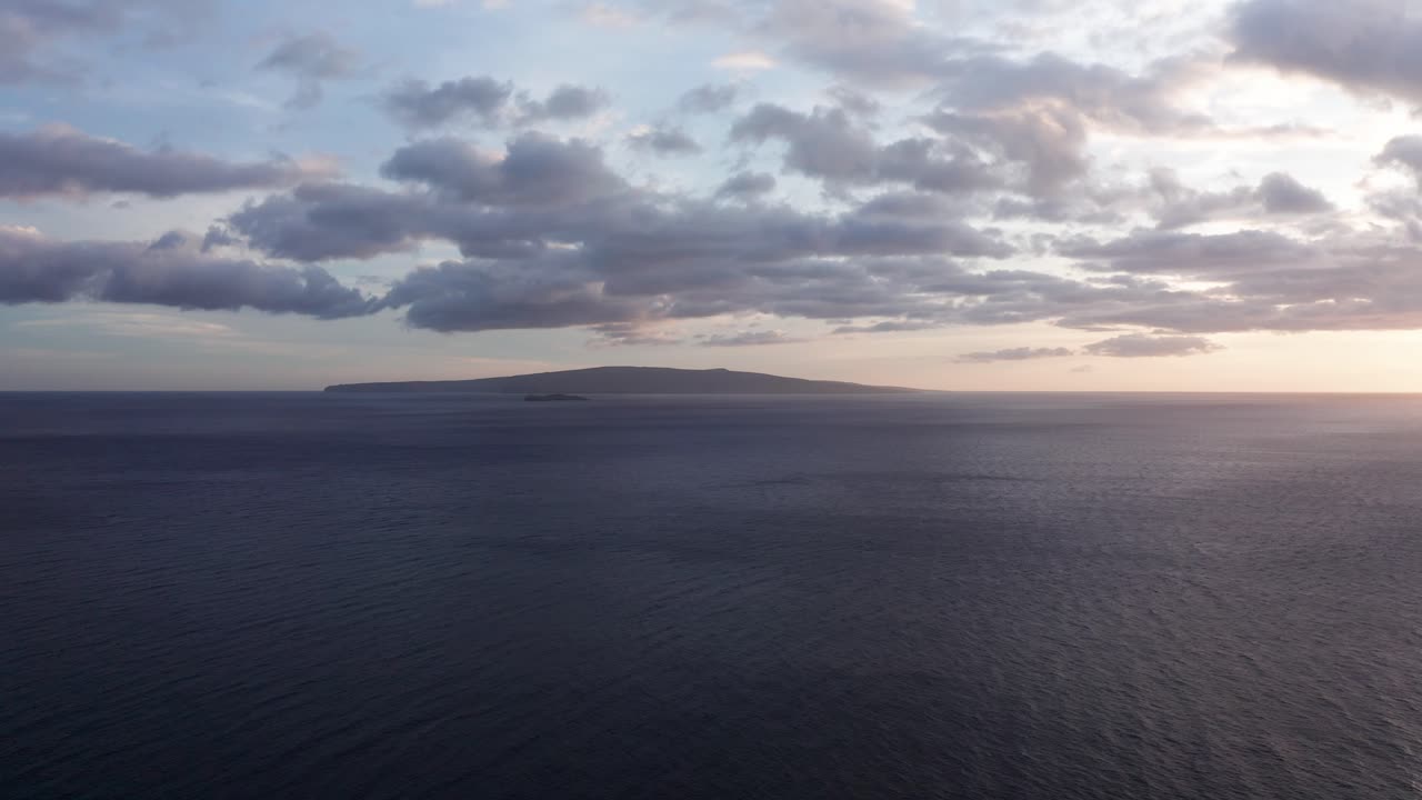 Super wide aerial dolly shot of Molokini Crater and the sacred island of Kaho'olawe at sunset from Wailea on the island of Maui, Hawai'i