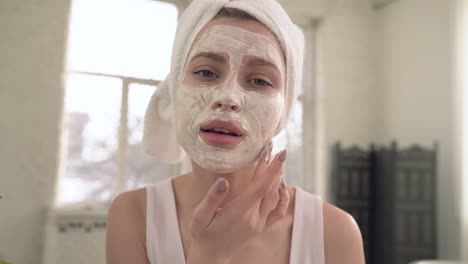 portrait of woman applying facial mask for skin care