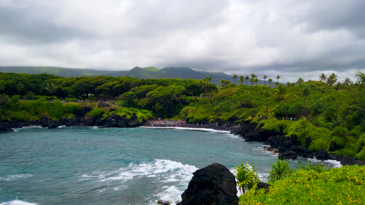 Black Sand Honokalani Beach, fast pan from blue Pacific Ocean's Keawaiki Bay on Road to Hana, Maui, Hawaii, 4k ProRezHQ