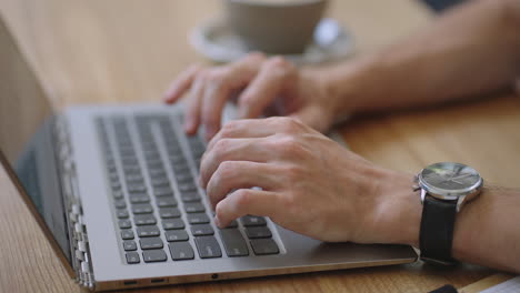 male hands of business man professional user worker using typing on laptop notebook keyboard sit at home office desk working online with pc software apps technology concept close up side view