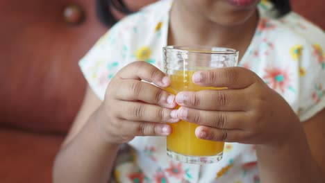 una joven bebe jugo de naranja