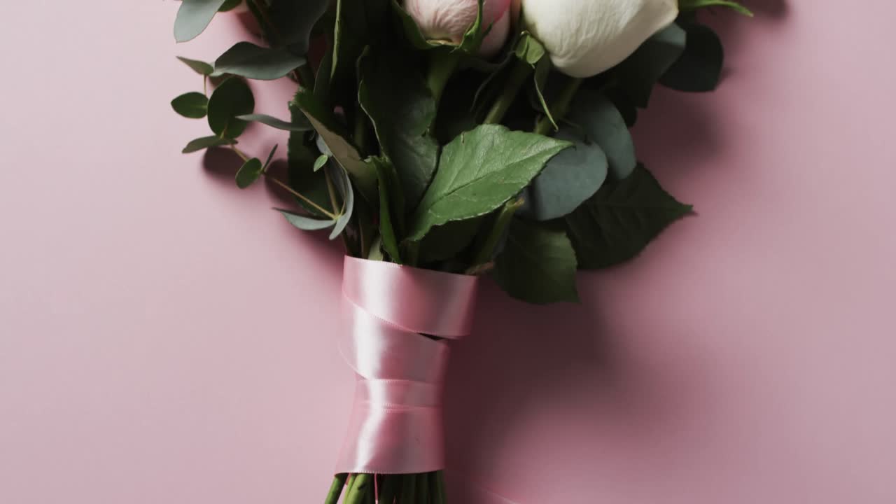 Video di un mazzo di rose bianche e rosa con nastro rosa e spazio per il testo su sfondo rosa