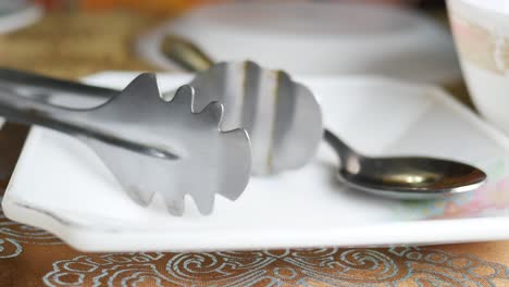 table setting with tongs and spoon