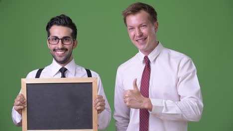 dos jóvenes empresarios multiétnicos trabajando juntos contra un fondo verde